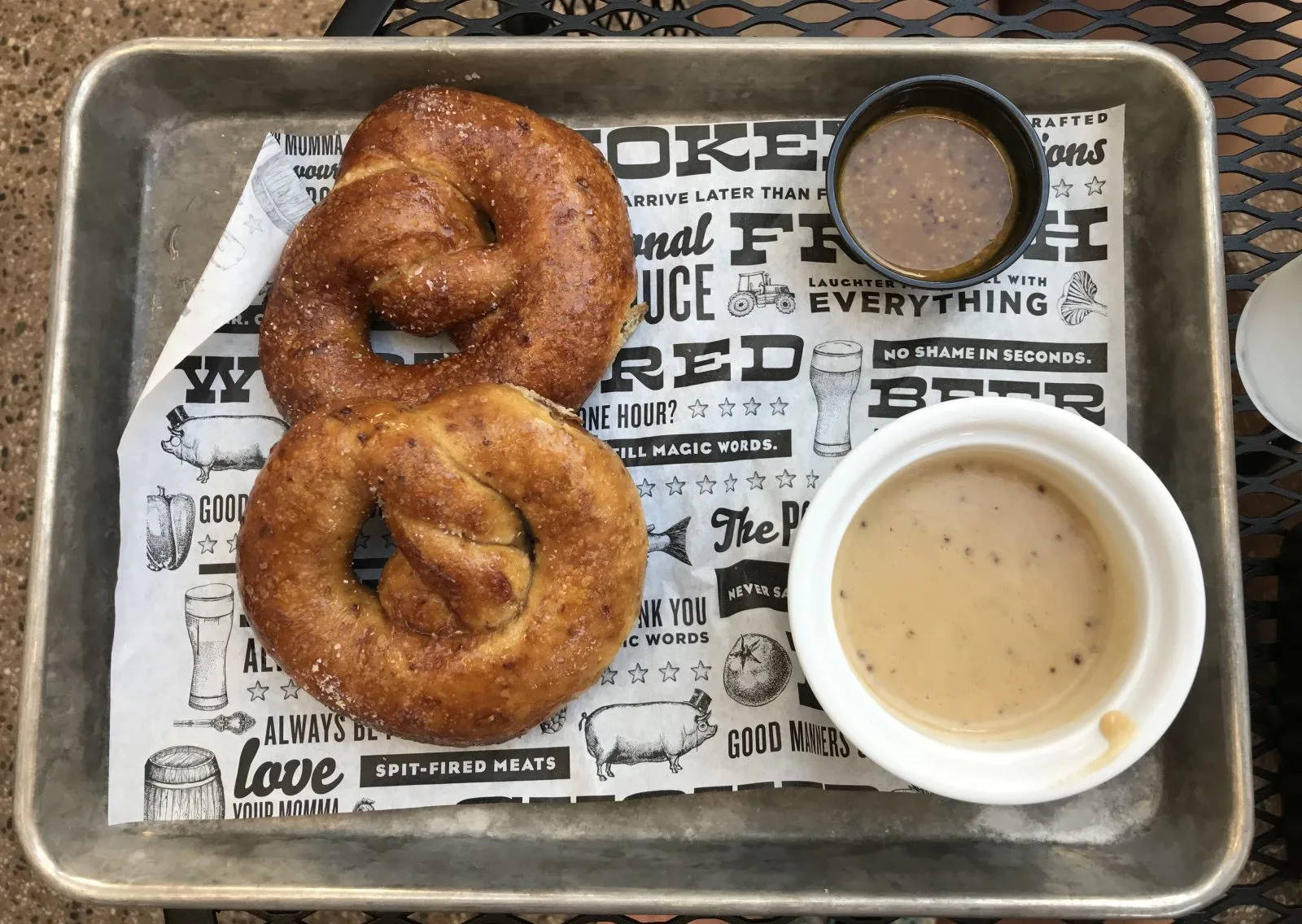 pretzels with dipping sauces served on a metal tray