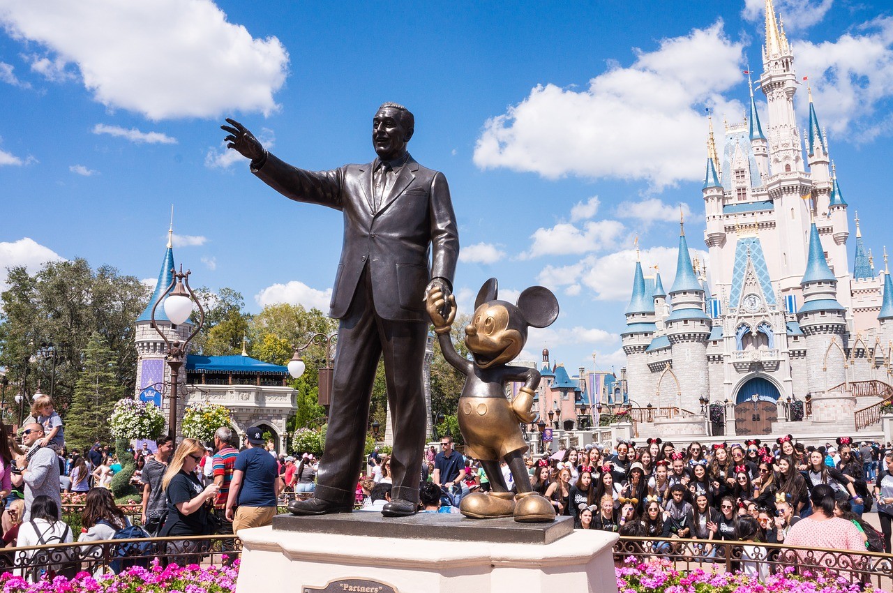 walt disney and mickey mouse statue in front of Cinderella's castle in magic kingdom
