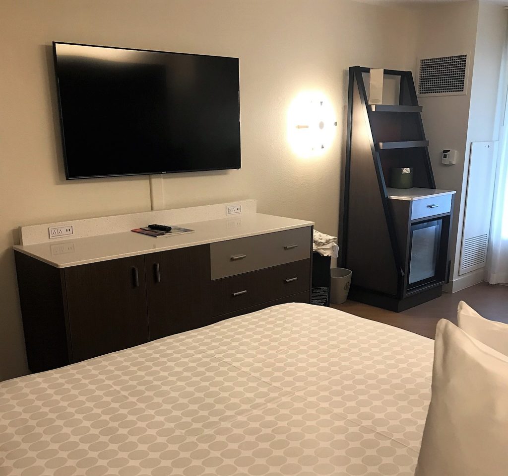 Bed, TV and storage in an All Star Movies Resort refurbished room