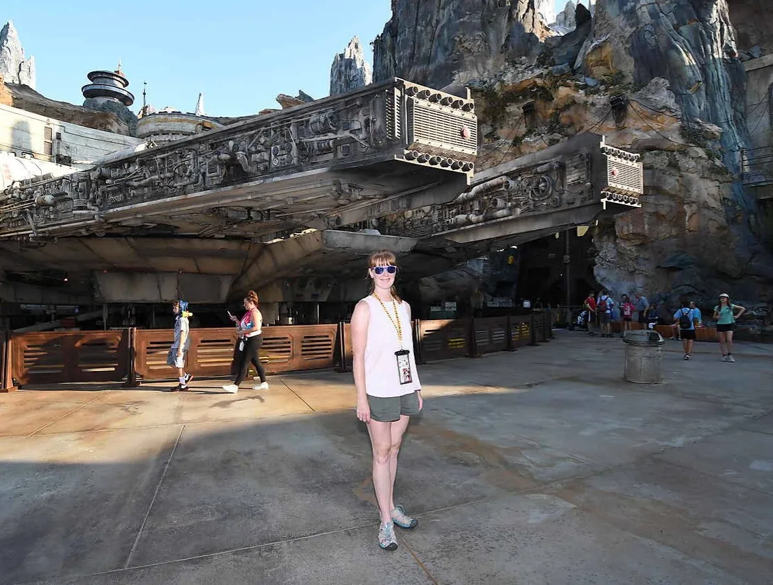 woman in from of the millenium falcon at star wars: galaxy's edge