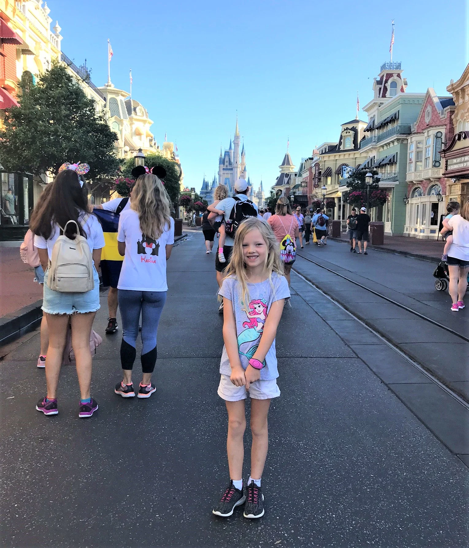 little girl standing in front of cinderella castle