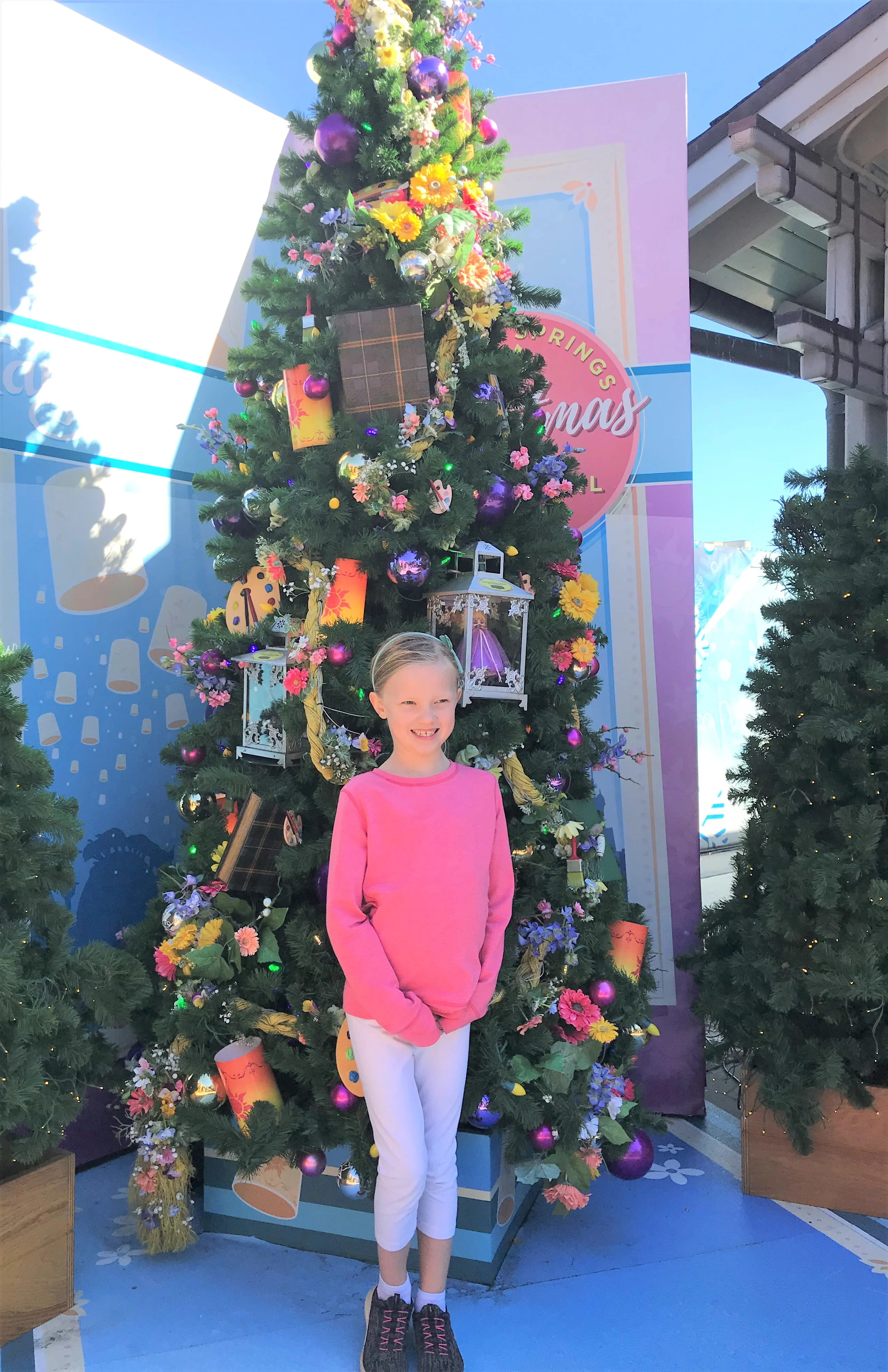 little girl posing in front of a christmas tree