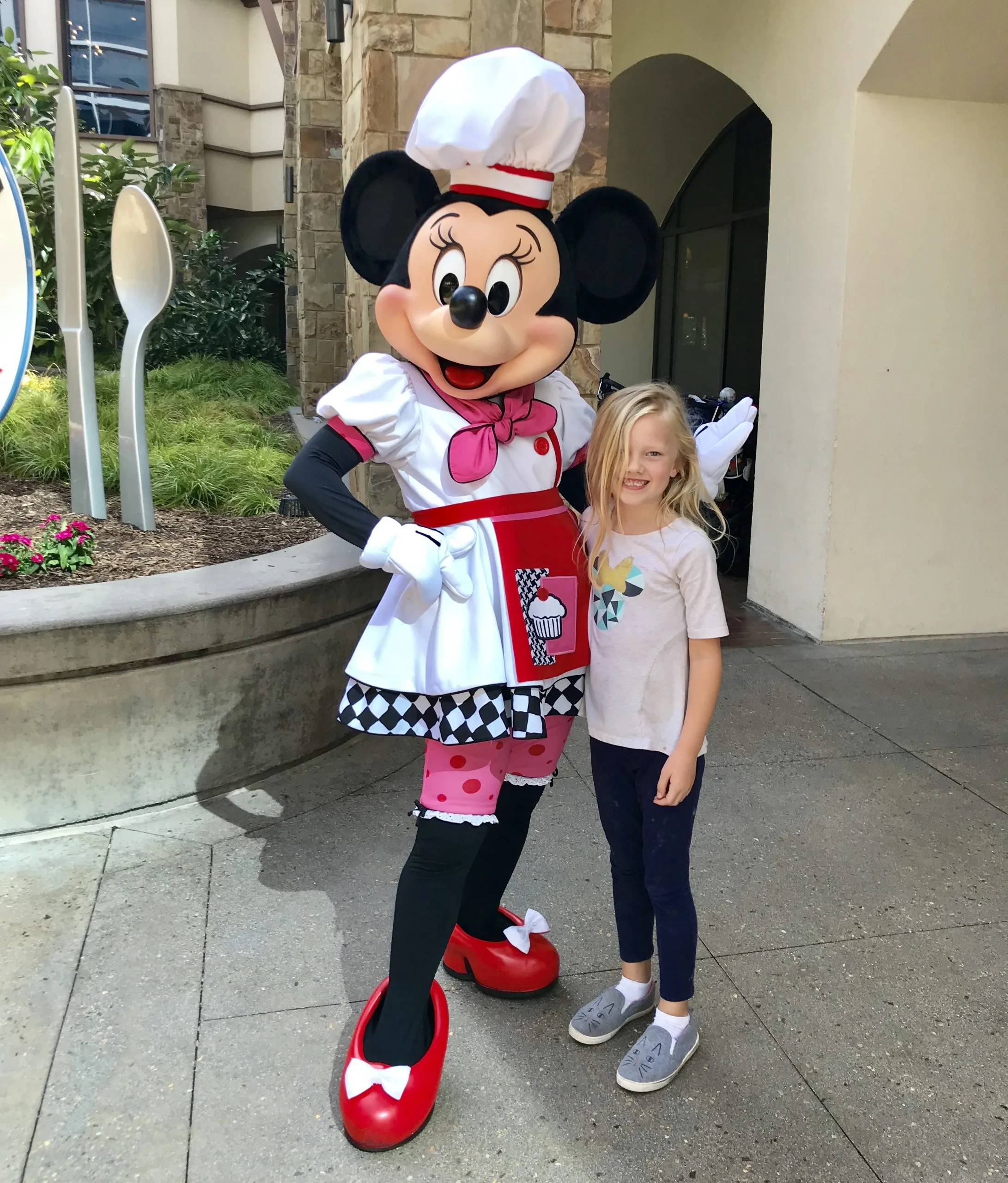 little girl posing with chef minnie mouse