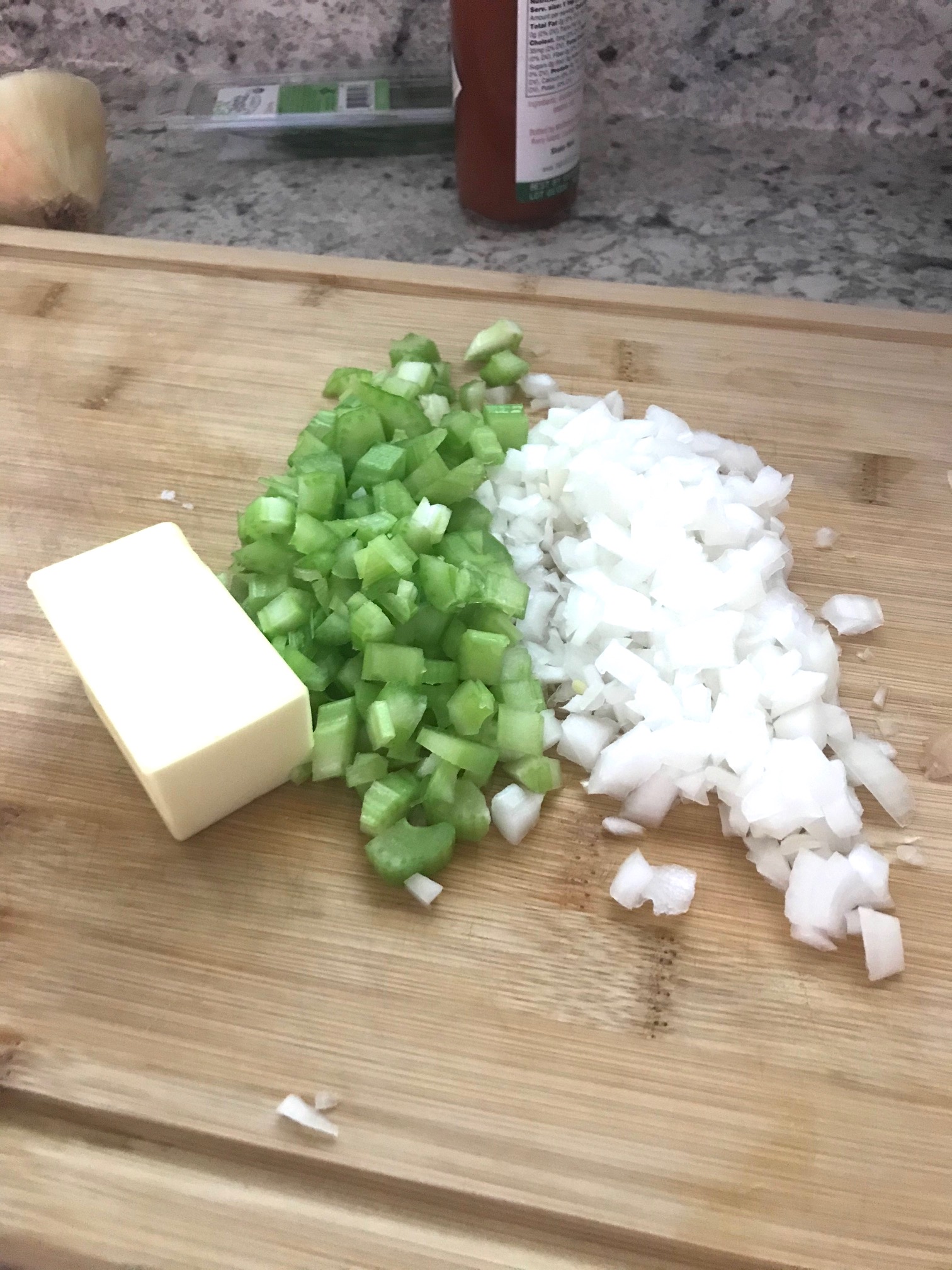 butter, diced onion, diced celery, on a cutting board