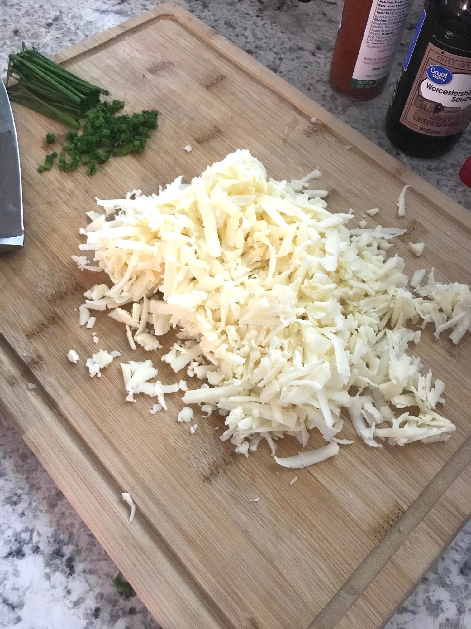 grated white cheddar cheese on a cutting board